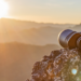 Pair of binoculars on a rock pointed toward a sunrise.