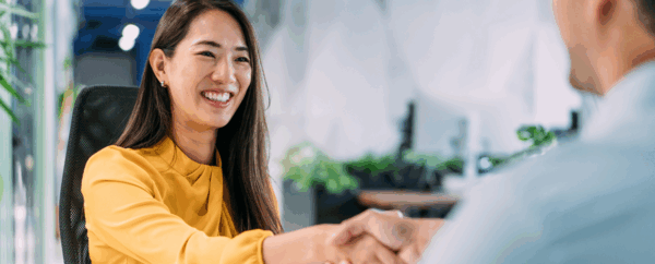 Smiling woman shaking a man's hand