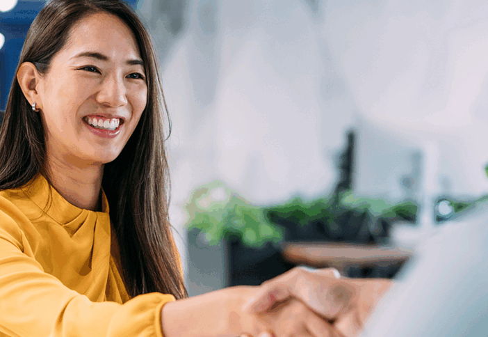 Smiling woman shaking a man's hand