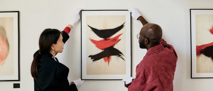Two people holding up a piece of art